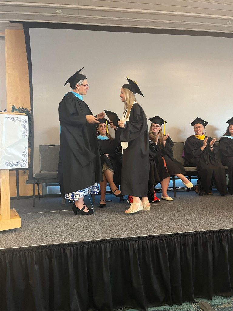 A graduation ceremony with graduates and faculty members is taking place.
