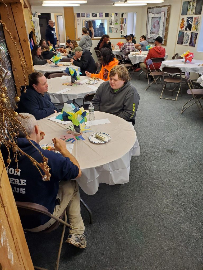 A crowded room with people sitting at tables.