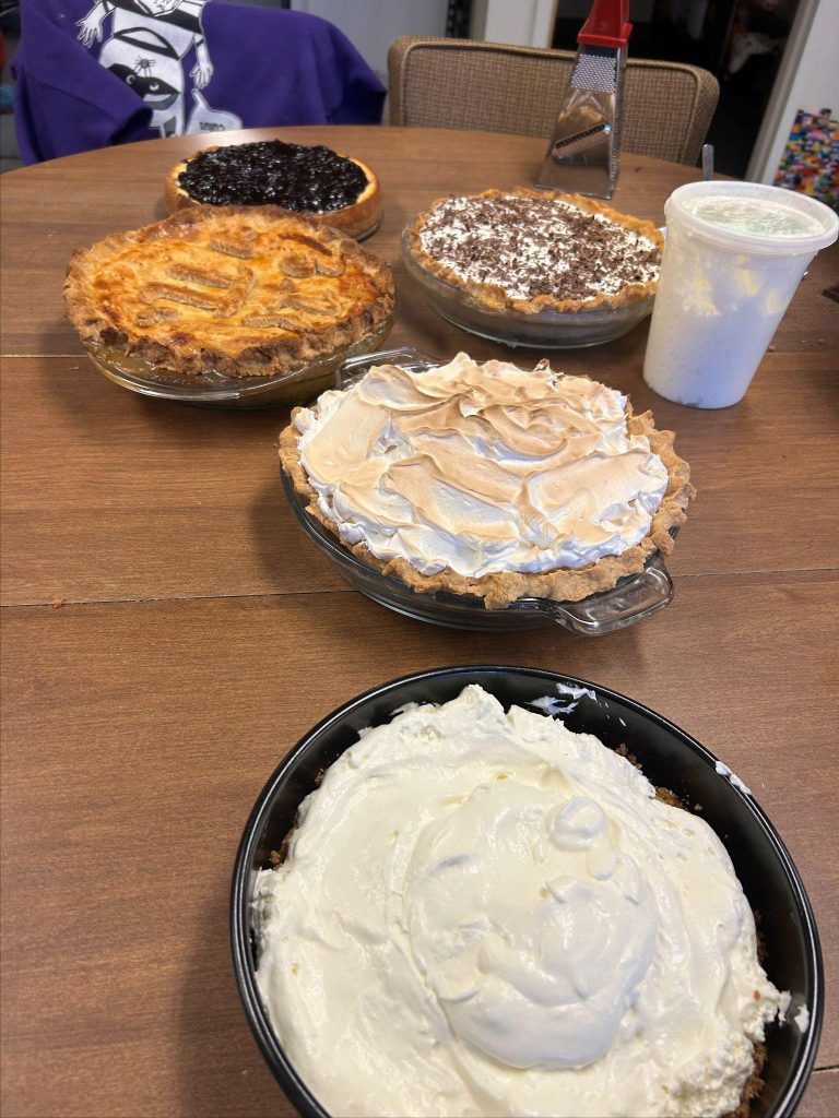 A table with various pies and a white cup.